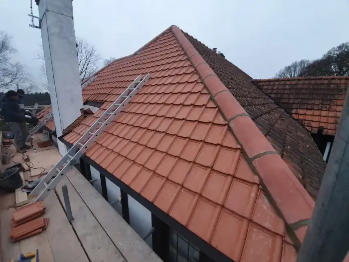 Newly laid red clay tile roof with new ridge tiles